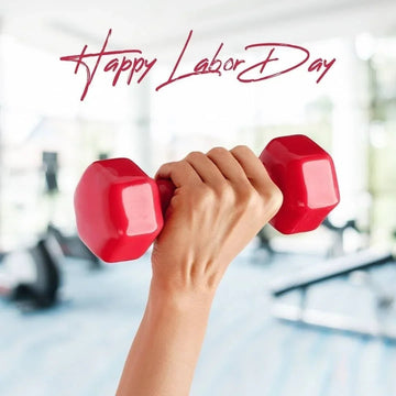 Hand holding red dumbbell in gym with Happy Labor Day text