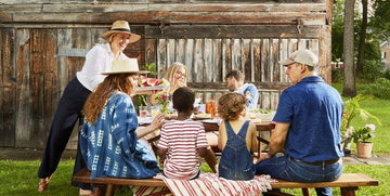 Multigenerational family enjoying outdoor Labor Day picnic with watermelon, drinks, and casual summer attire
